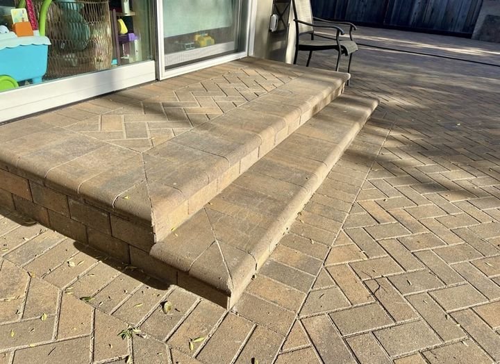 Paver steps with bullnose caps over a herringbone patio